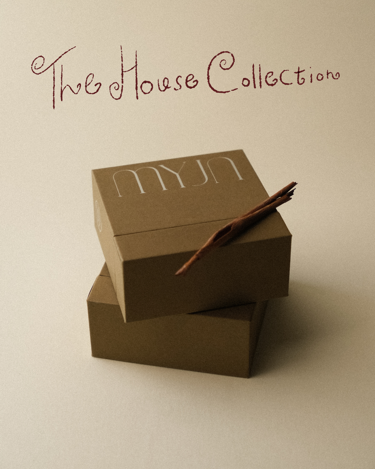 Two light khaki brown jewellery boxes stacked together with a piece of tree bark as a prop, photographed on a warm toned wabi sabi backdrop. The earthy hue echoes the natural colour of the bark.