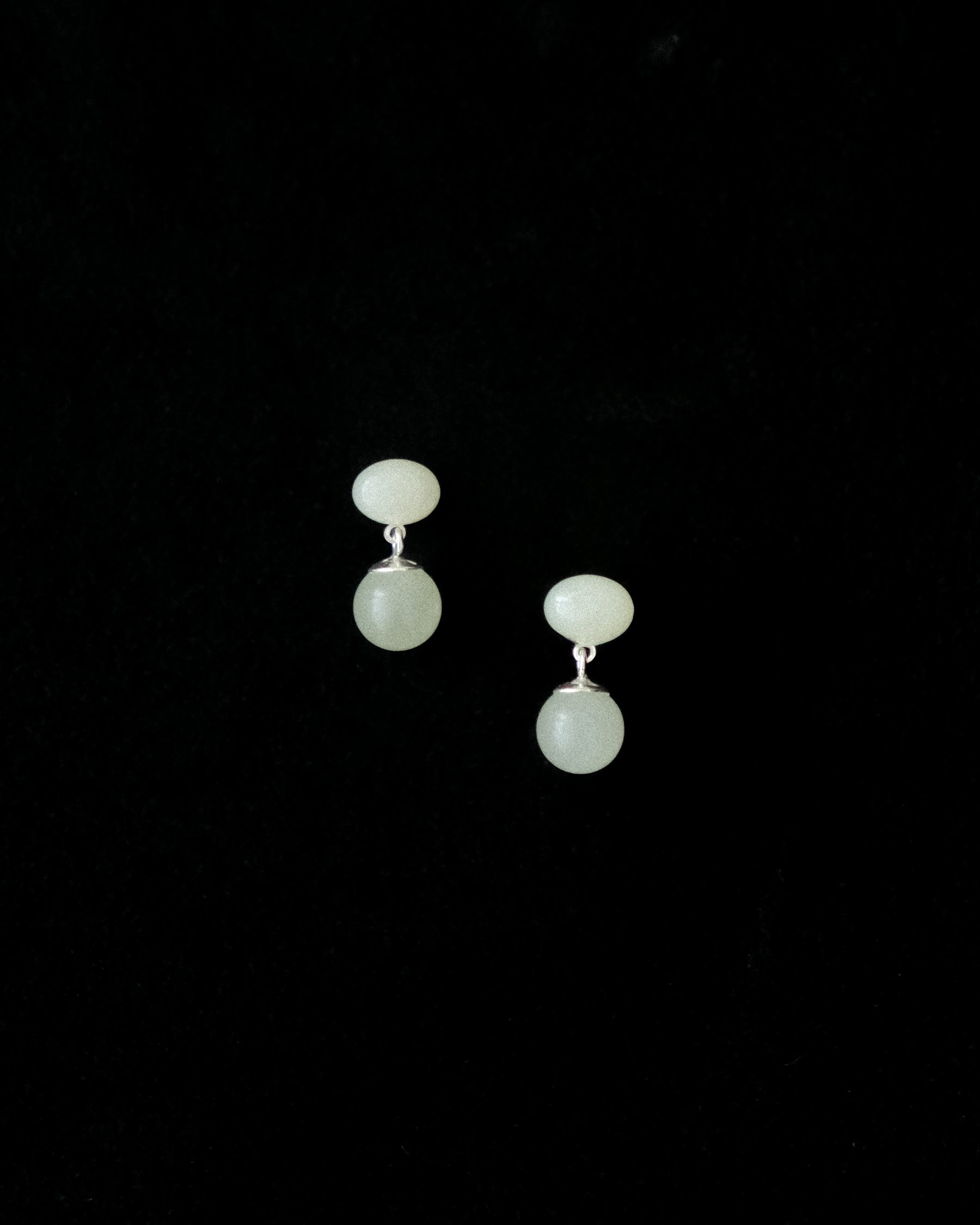 Pair of earrings made of Hetian Jade on a black background