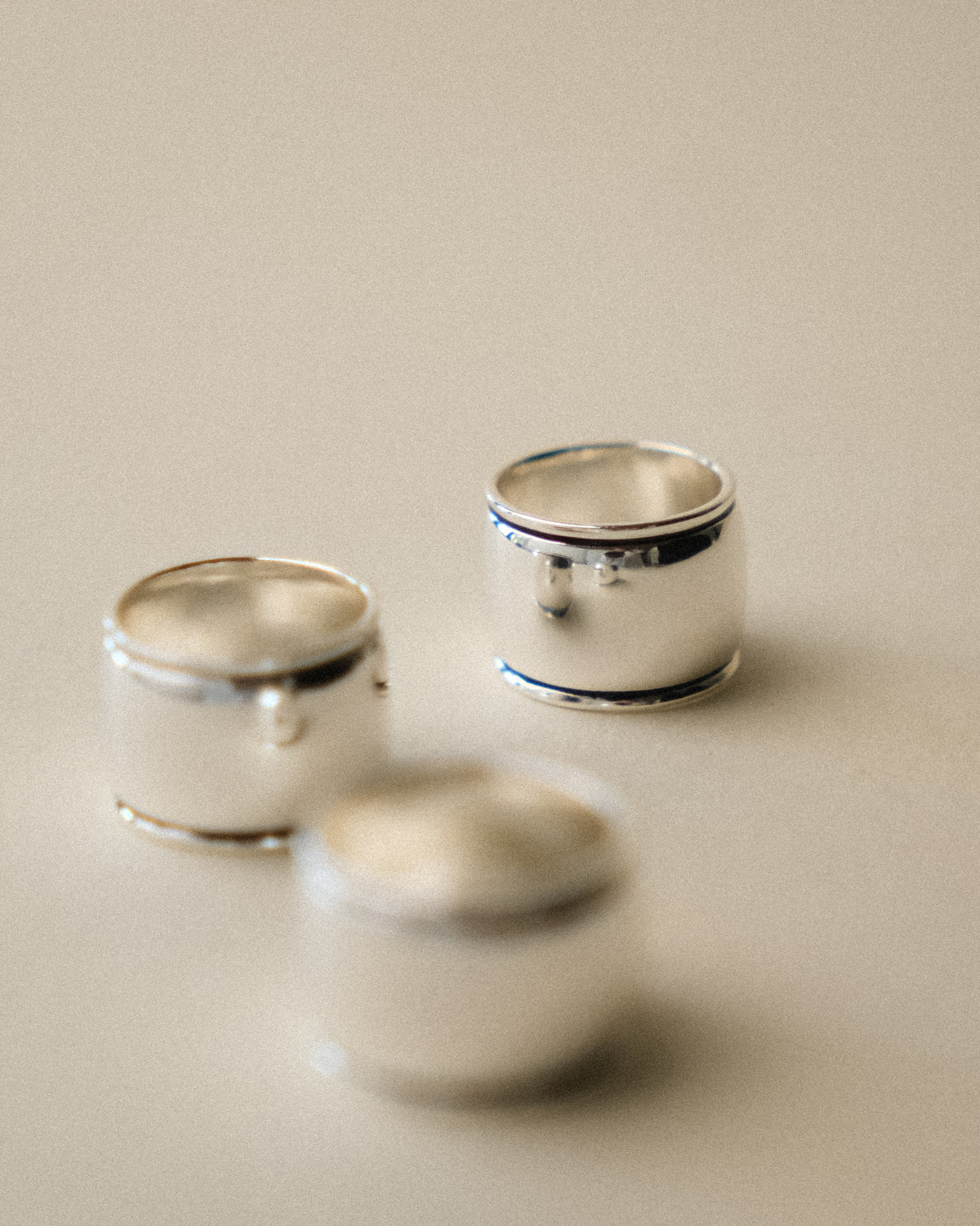 Three available ring sizes displayed from the front against a warm-toned wabi-sabi backdrop.