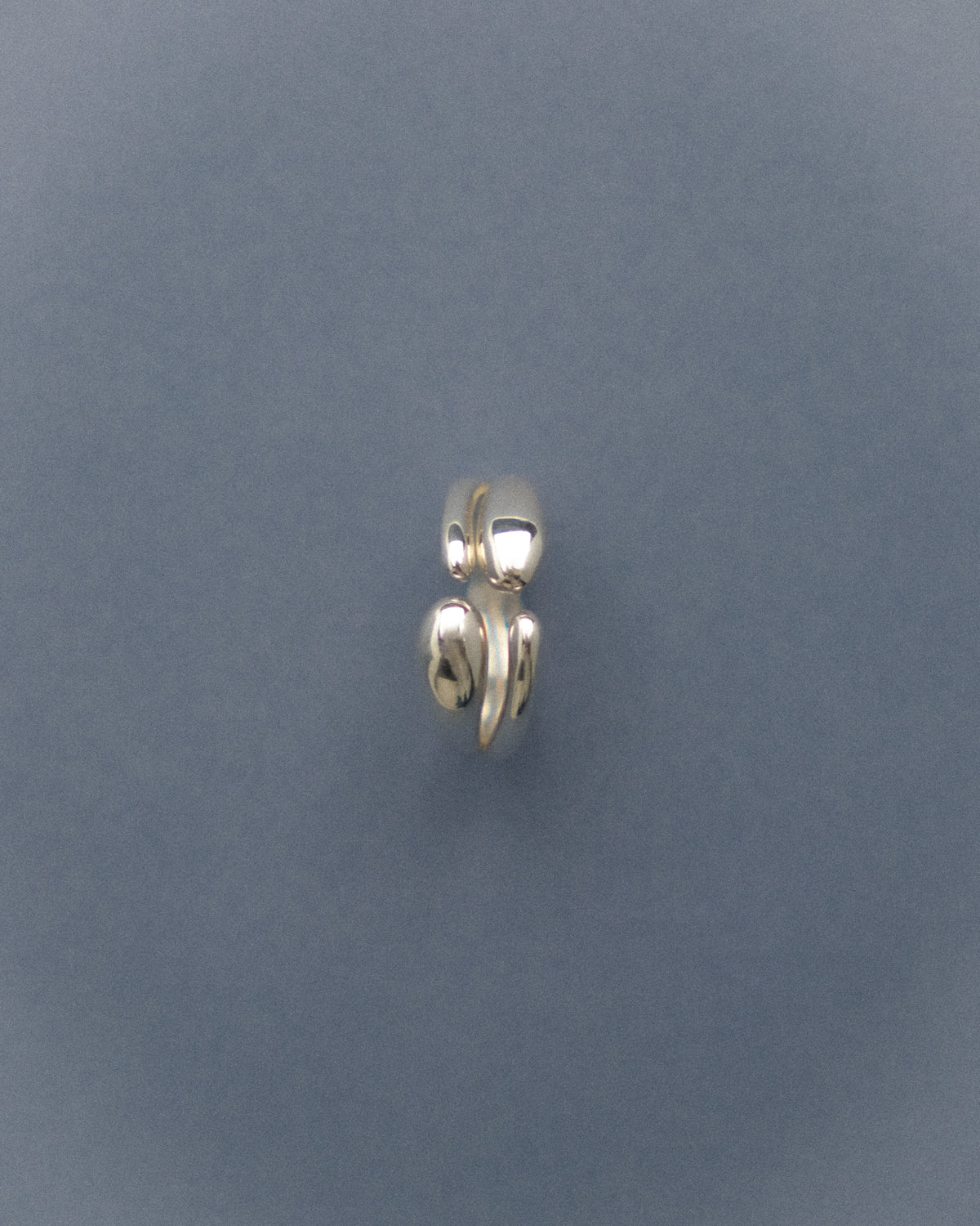 Silver double droplet ring on a gray blue background