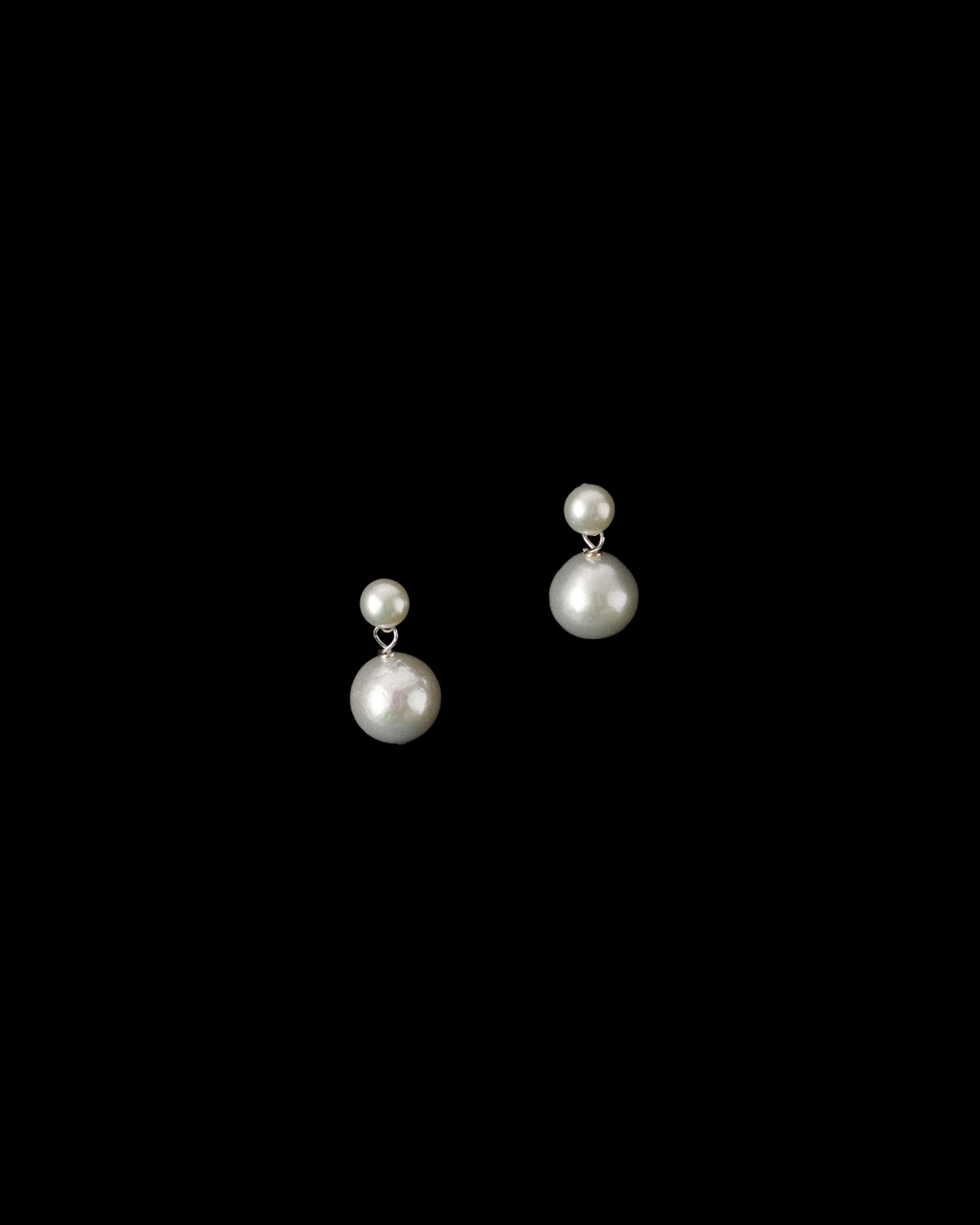 Double fresh water pearl drop earrings on a black background.