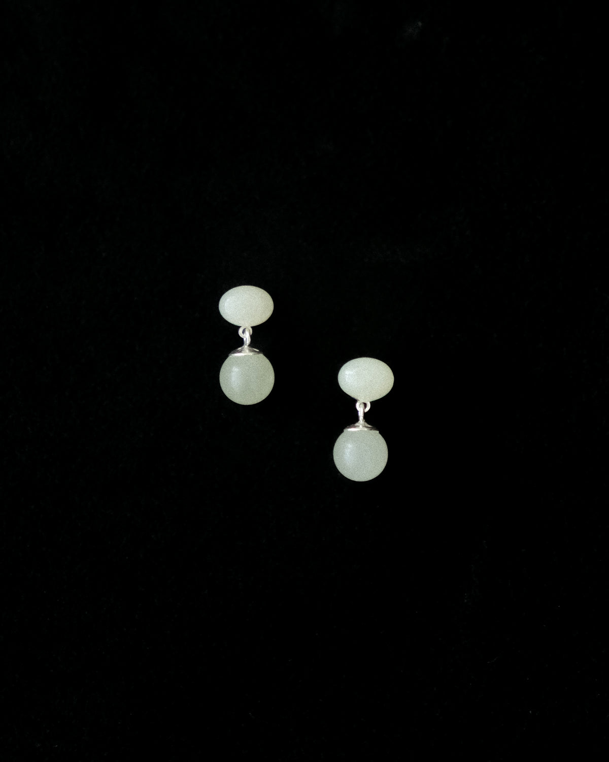 Pair of earrings made of Hetian Jade on a black background