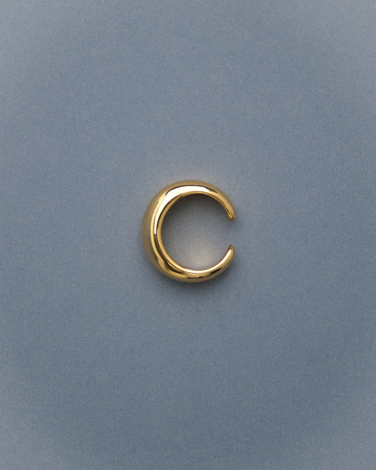 Gold-plated brass open pinky dome ring capture from top against a blue background.