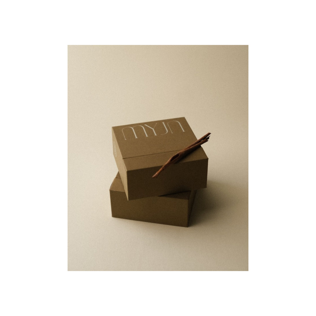 MYJN Tree Bark Edition box in hazelnut-husk paper beside a piece of tree bark