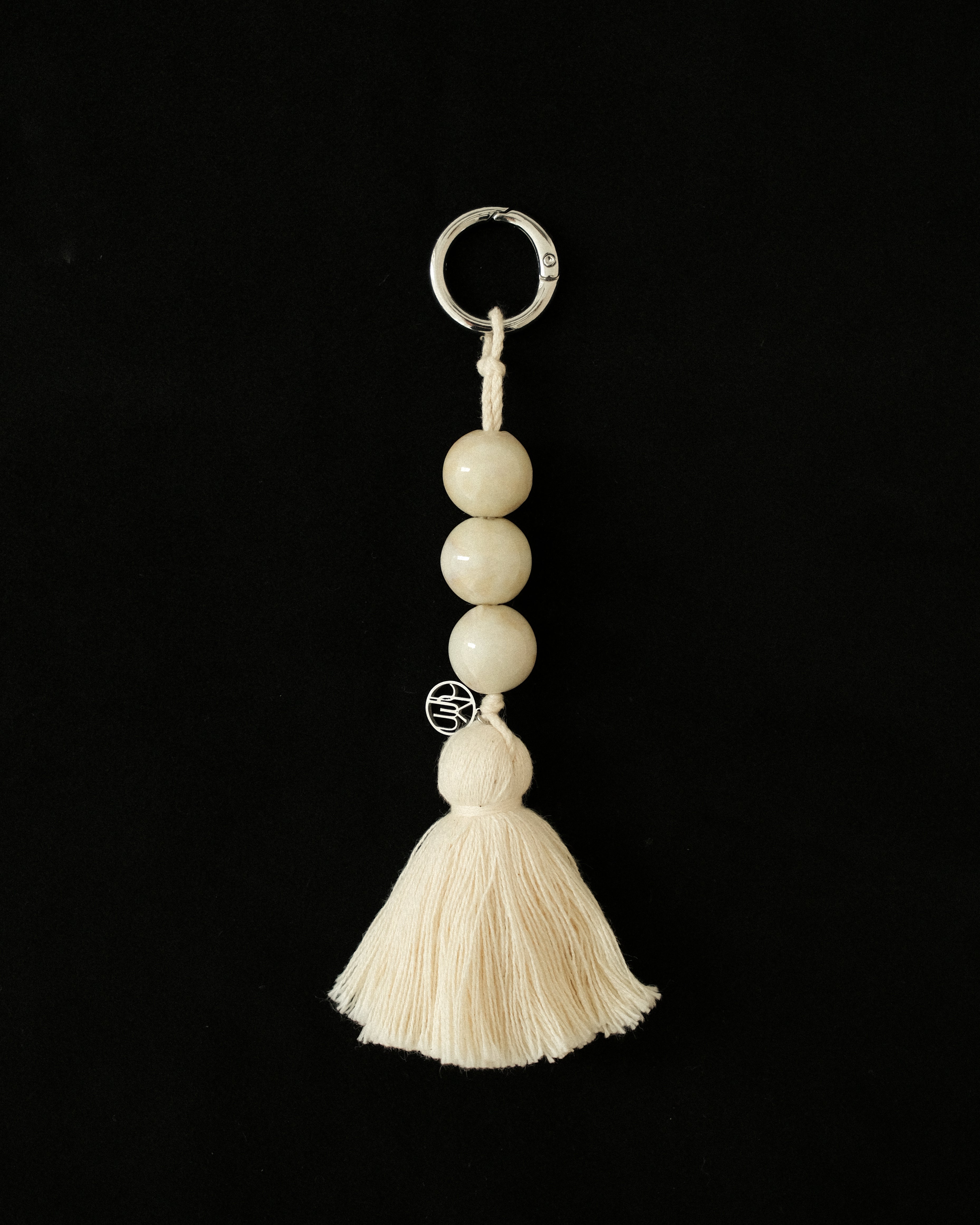 MYJN keychain with beads and tassel on a black background