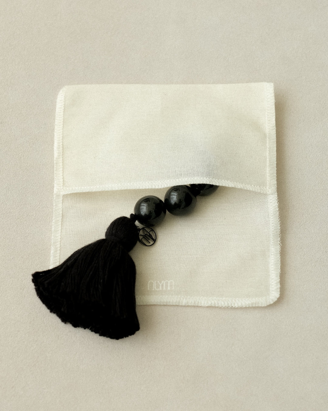The "MO” Talisman 003 half inside the linen pouch