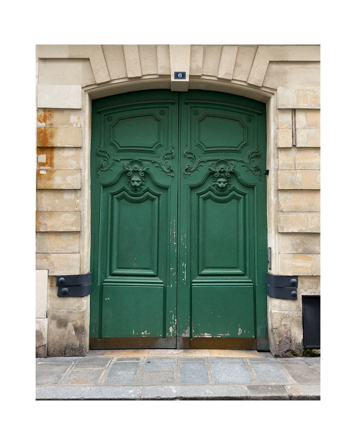 Green ornate door on a stone building, from Paris